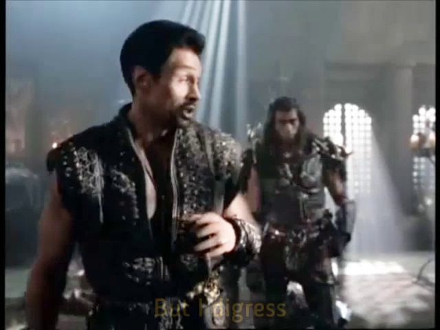 a man in a black leather outfit is standing next to another man in a dark room .