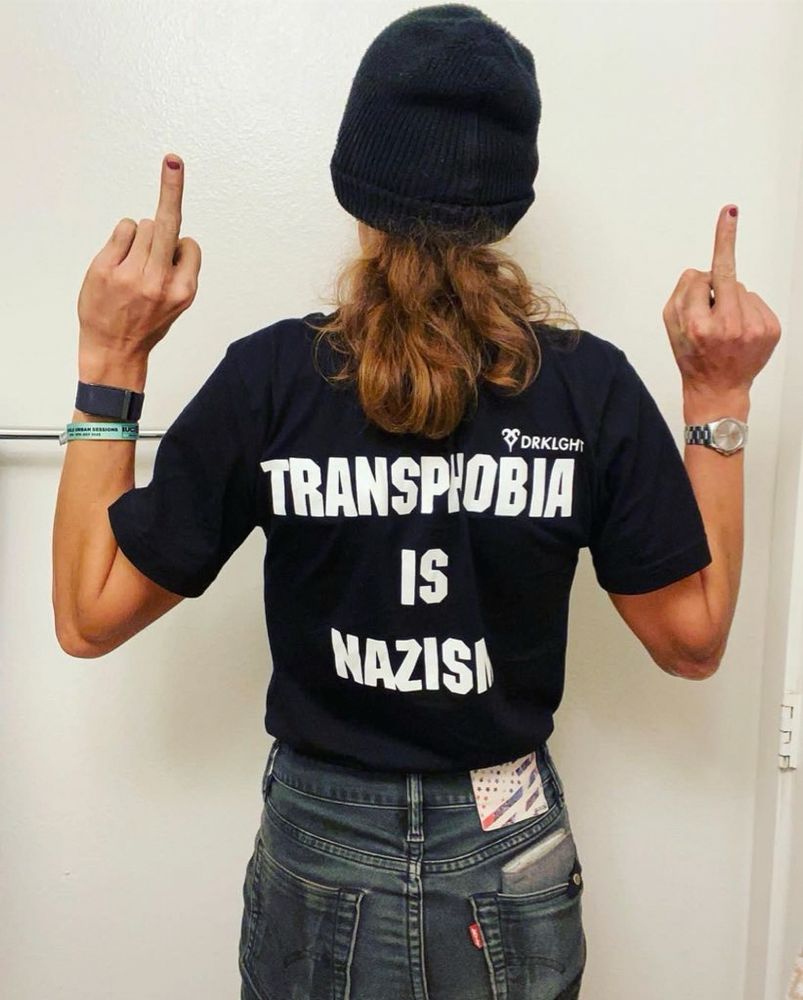 Trans Olympian Chelsea Wolf in our transphobia is Nazism shirt. The back says transphobia is nazism