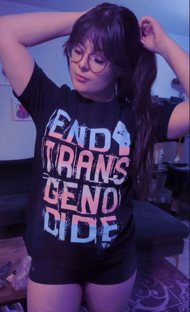 Blaire wearing our end trans genocide shirt from DRKLGHT.com that donates to trans people