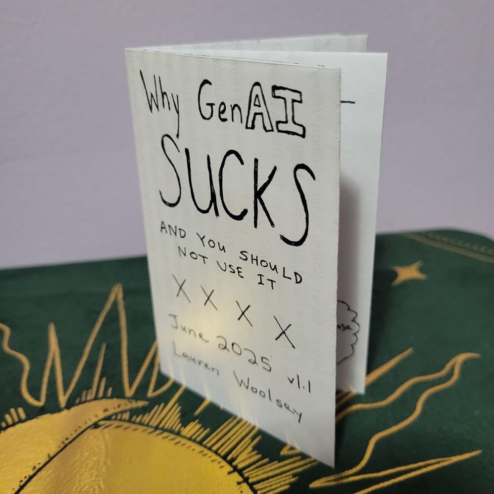 A simple black and white zine from a folded piece of paper, with the title "Why GenAI SUCKS AND YOU SHOULD NOT USE IT" dated June 2025, version 1.1, author Lauren Woolsey. The zine is sitting on a green and gold cloth with a sun motif.