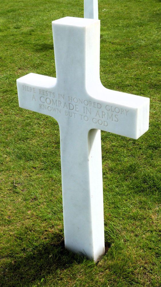 Picture of the grave of an unknown American soldier in Colleville-Sur-Mer, Normandy, France. The tombstone reads : "Here rests in honored glory a comrade in arms known but to god"