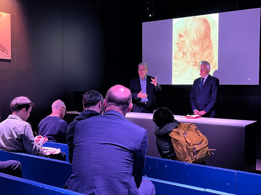 Michel Cabaret et François Saint Bris dans la salle d'animation, présentant l'exposition aux journalistes présents, assis en face d'eux