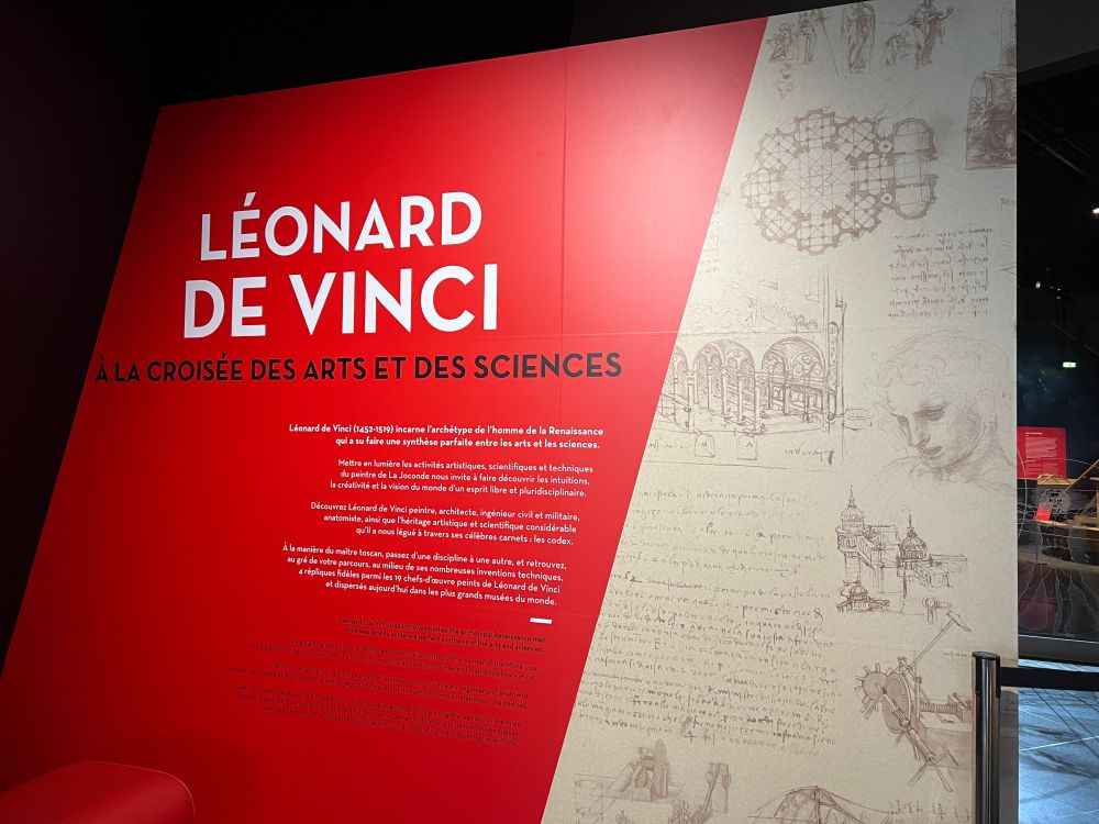 Panneau d'entrée de l'exposition sur lequel on peut lire le titre de l'exposition "Léonard de Vinci : à la croisée des arts et des sciences" ainsi qu'un résumé.