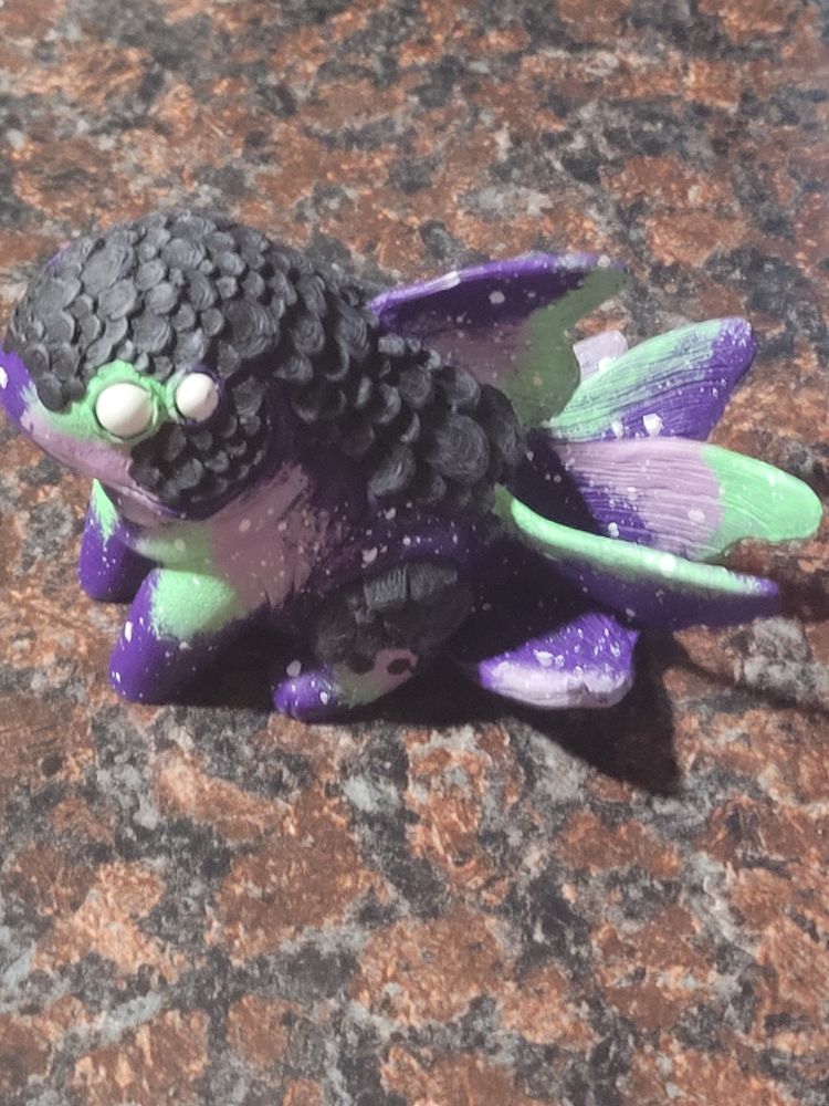 Winged amphibians creature with scales and cosmic pattern coloration.