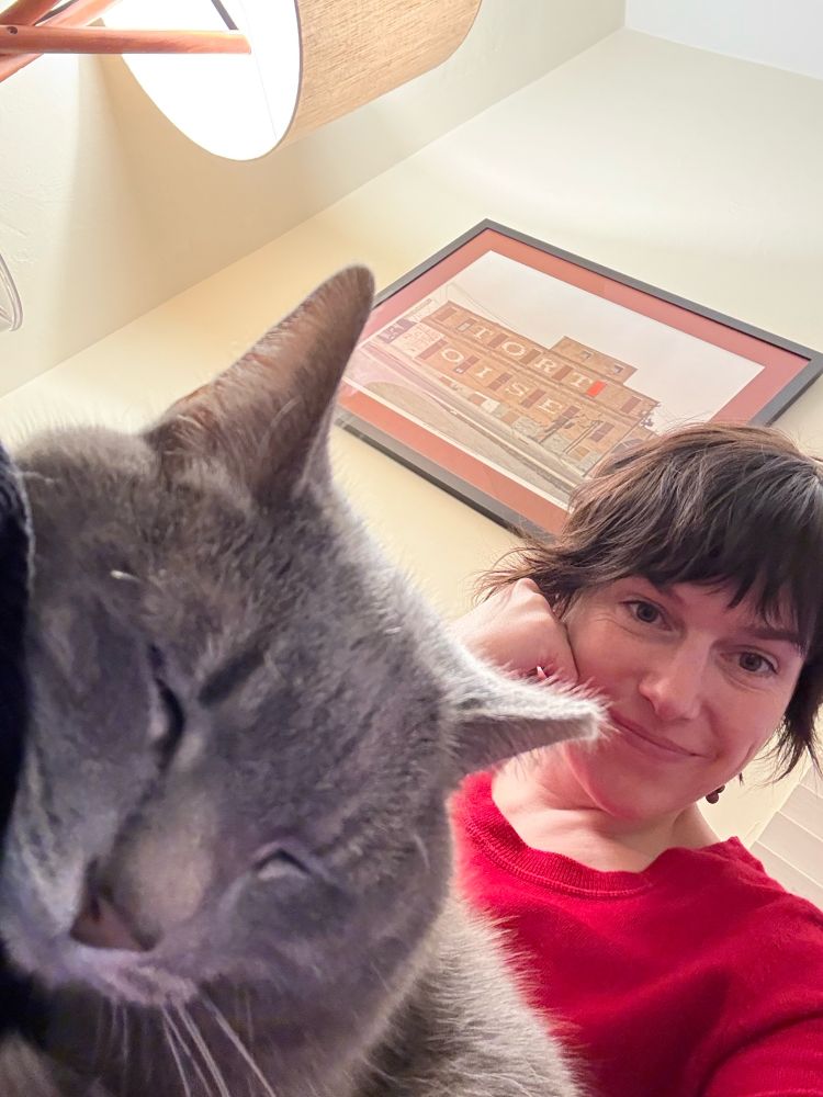 A selfie that includes my cat, who is sleeping sweetly on my lap.