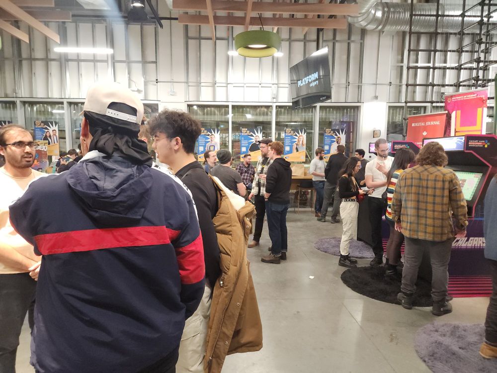 Many people playing games at a game development demo day