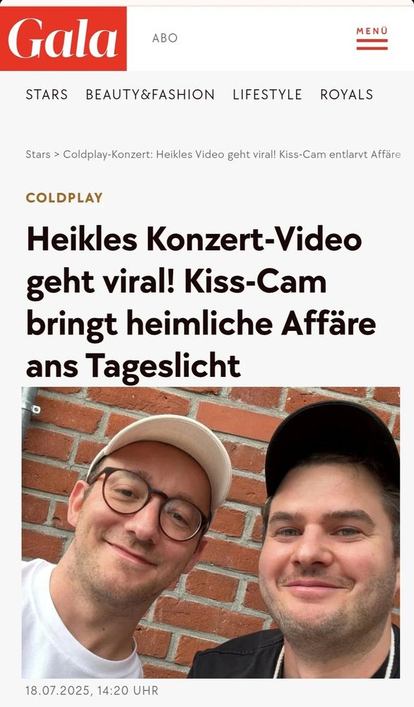 Dax Werner und Moritz Hürtgen posieren lächelnd für ein Selfie vor einer roten Backsteinwand. Darüber steht die Schlagzeile eines Gala-Artikels: „Heikles Konzert-Video geht viral! Kiss-Cam bringt heimliche Affäre ans Tageslicht“. Datum: 18.07.2025, 14:20 Uhr.

