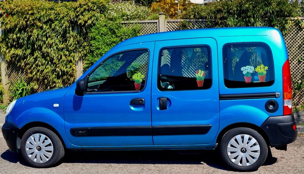 Bright blue Renault Kangoo with flowers in the window