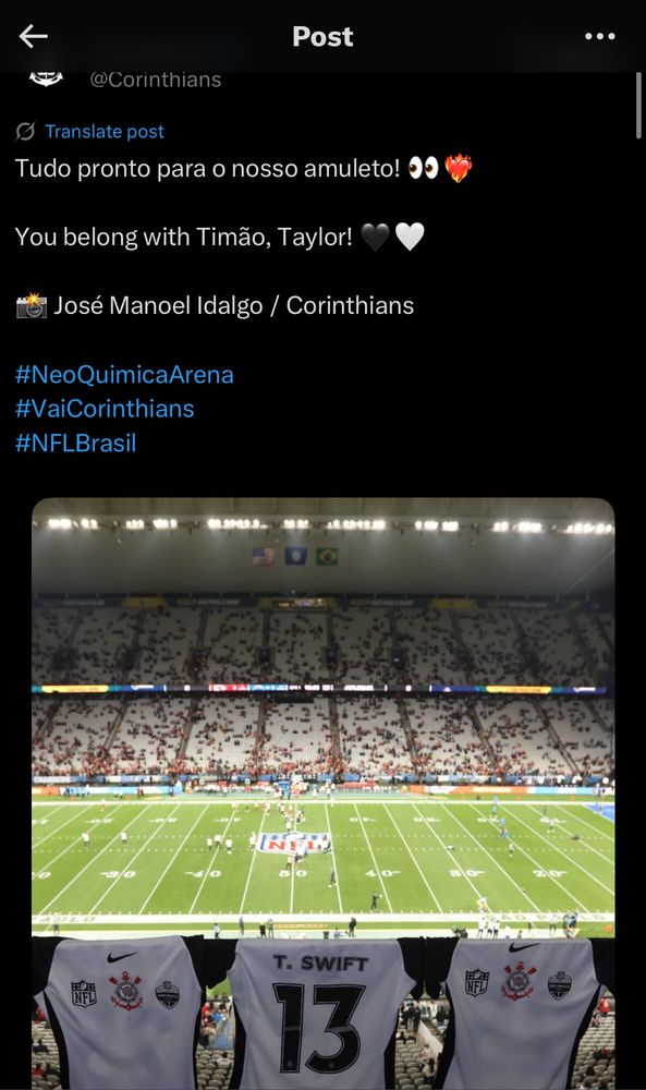 Print de uma postagem do Corinthians no Twitter que tem uma camisa personalizada para a Taylor Swift com o número 13. 
No post a legenda é: “Tudo pronto para o nosso amuleto! 👀❤️‍🔥

You belong with Timão, Taylor! 🖤🤍

📸 José Manoel Idalgo / Corinthians” (e algumas hashtags)