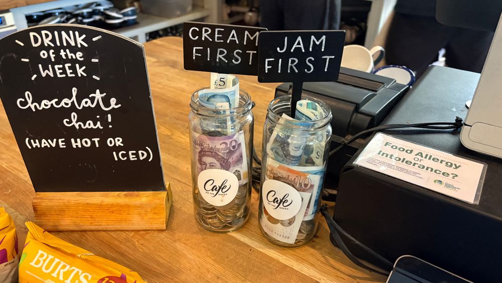 Picture of two tip jars labelled "Cream First" and "Jam First".