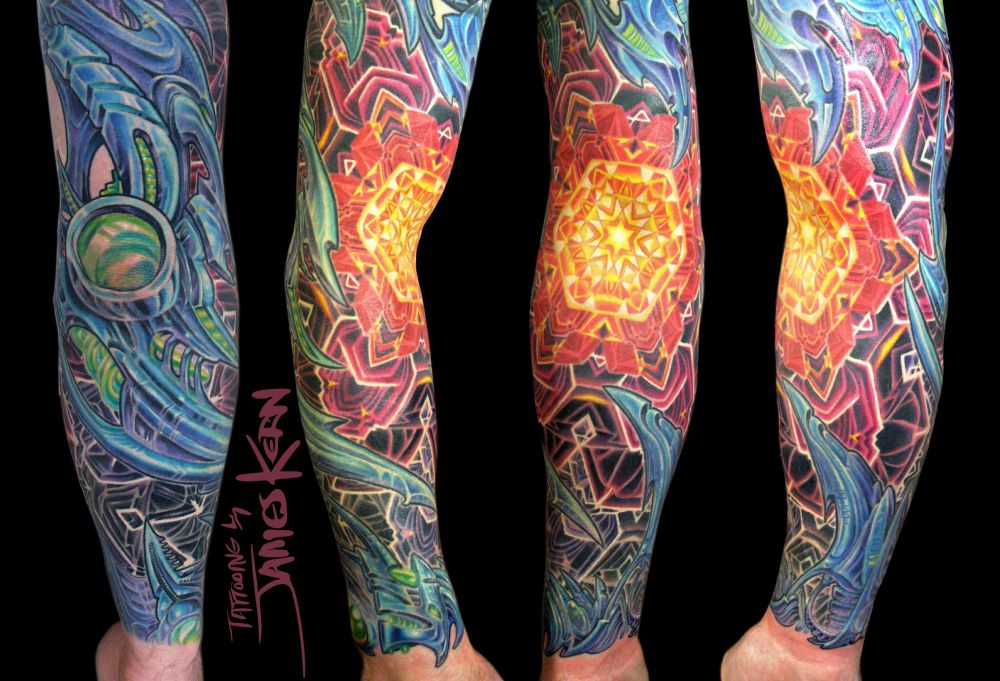 Man’s arm with a tattooed biomechanical sleeve with a glowing crystal mandala design in center. 