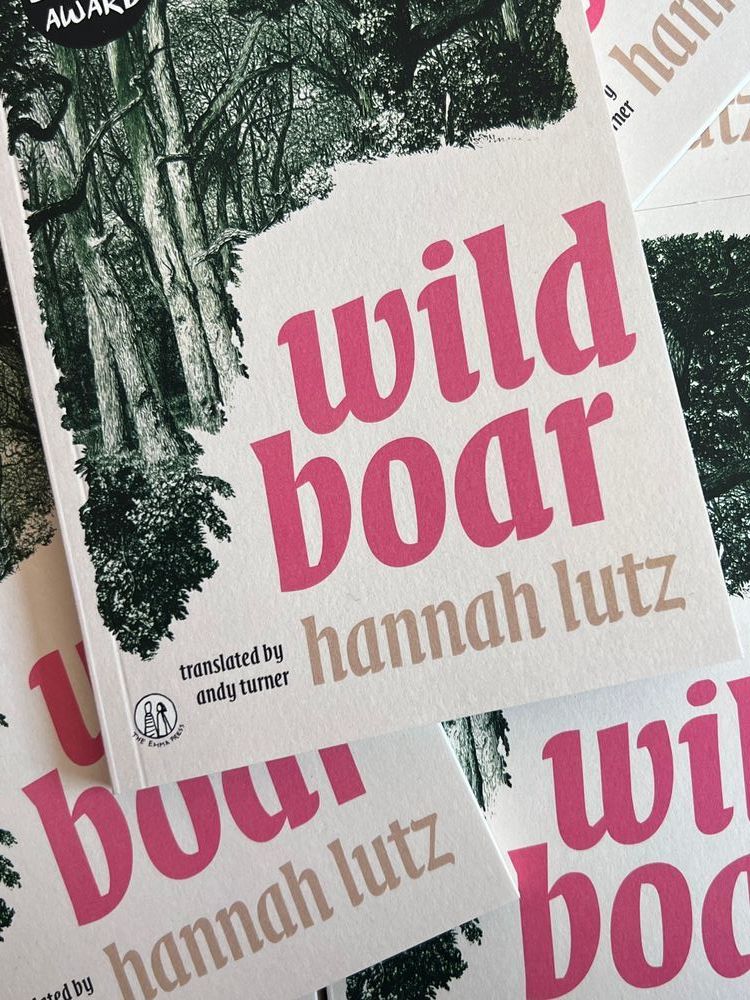 Copies of 'Wild Boar' which have a cream cover, pink text and a green, illustrated forest emerging through.