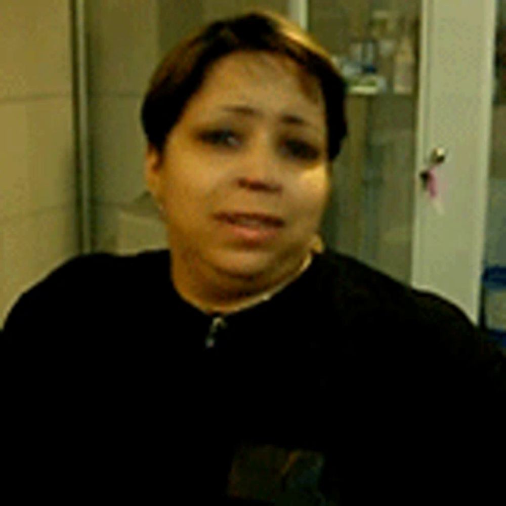 a woman in a black shirt is standing in front of a door