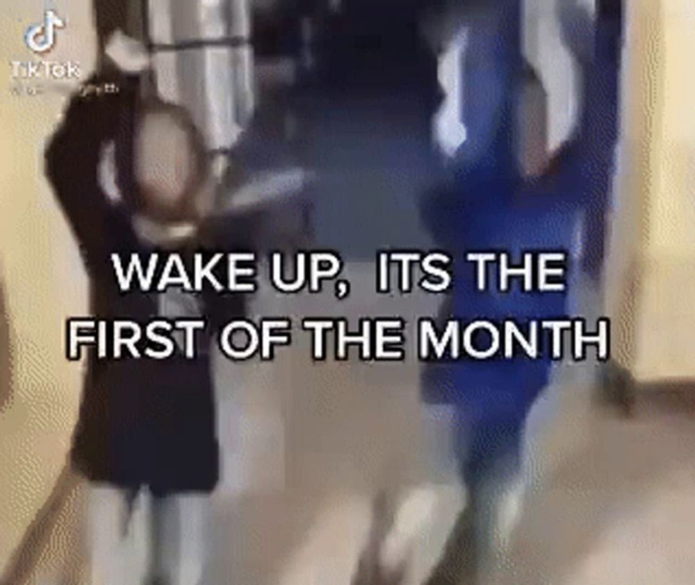 a group of people standing in a hallway with the words `` wake up , it 's the first of the month ''