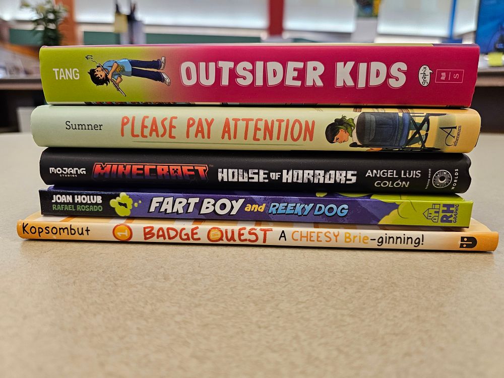 Stack of five books on a table:
Outsider Kids by Betty C. Tang
Please Pay Attention by Jamie Sumner
Minecraft House of Horrors by Angel Luis Colon
Farther Boy and Reeky Dog by Joan Holub with Rafael Rosado
BadgeQuest by Guy Kopsombut