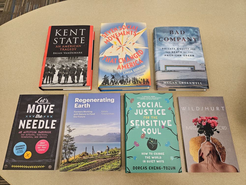 Seven nonfiction books on a table, from top left: Kent State by Brian VanDeMark, Seven Social Movements That Changed America by Linda Gordon, Let's Move the Needle by Shannon Downey aka Badass Cross Stitch, Regenerating Earth by Kelsey Timmerman, Social Justice for the Sensitive Soul by Dorcas Cheng-Tozun, and Wild/Hurt by Meg Ford.