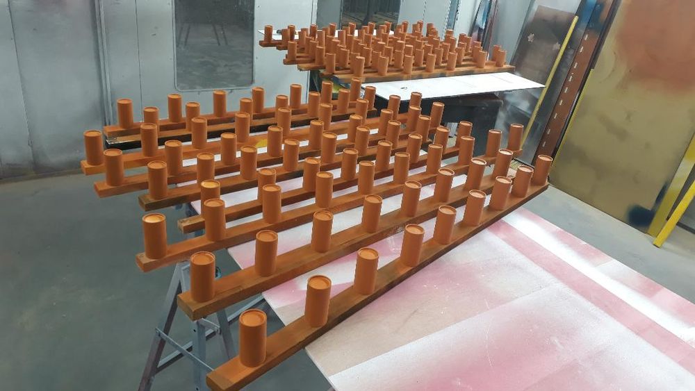 more of the cylinders, maybe at least a hundred, now fully sprayed up in a sort of terracotta colour.
