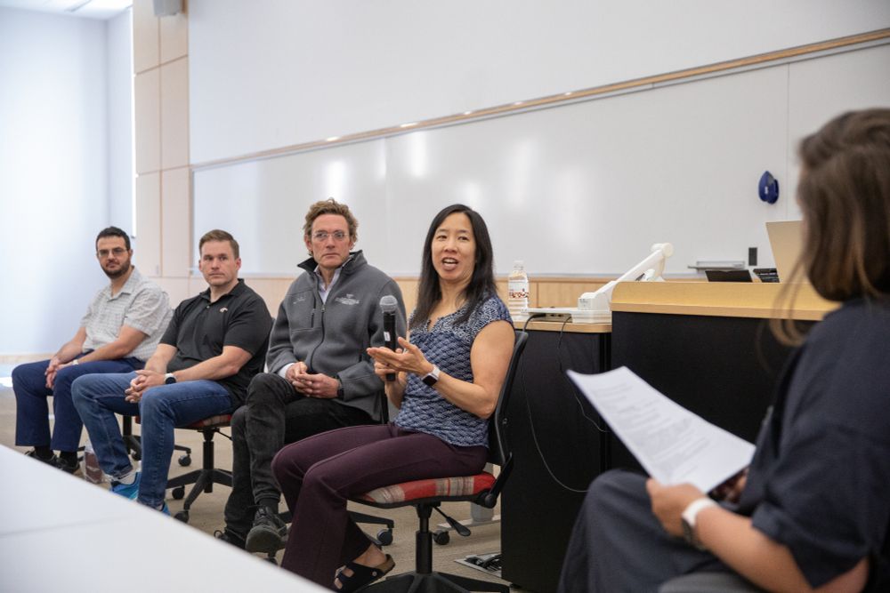 Discussion panel of four professors at the front of a classroom