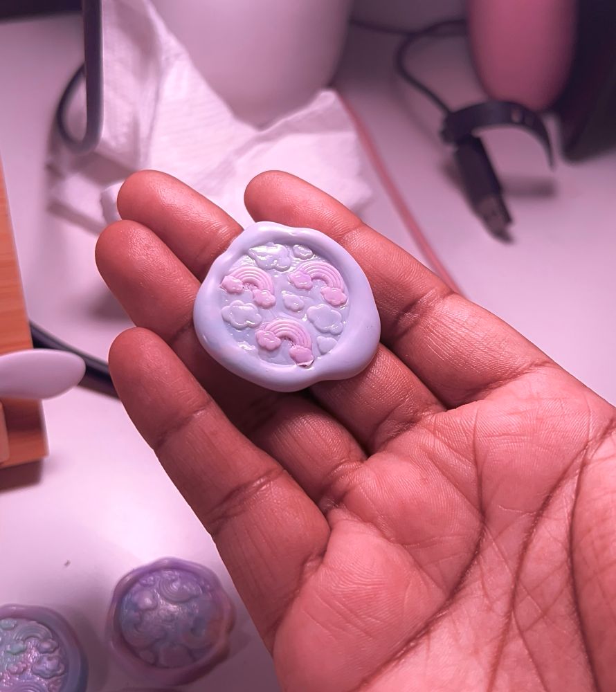 a picture of a wax seal, held on raynna’s hand