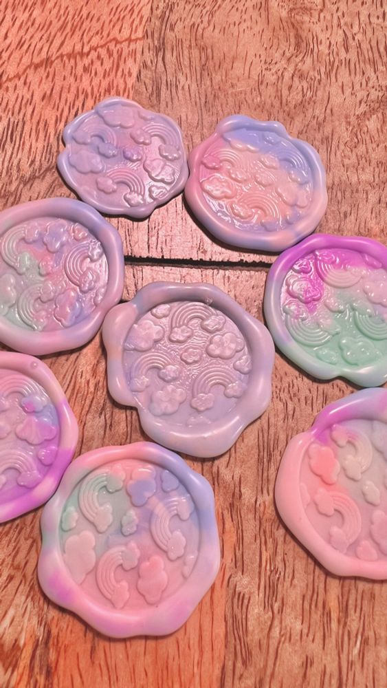 8 wax seals on a wooden display board. all have various combinations of pastel colors