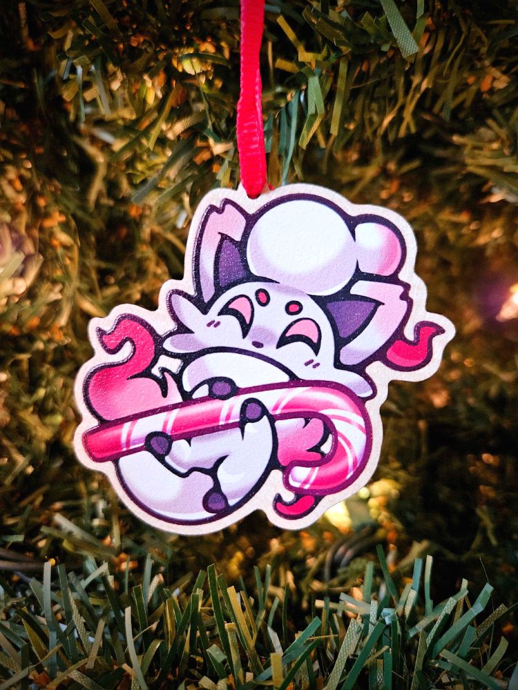 A wooden holiday ornament featuring a Pokemon, Hisuian Zorua, holding a large candy cane.
