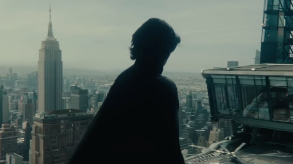 sky shot of daytime but cloudy NYC with all black figure of a man