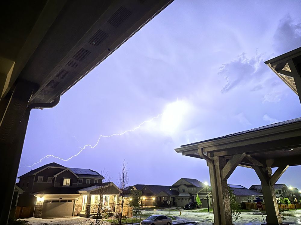 A photo of lightning striking over a neighborhood 