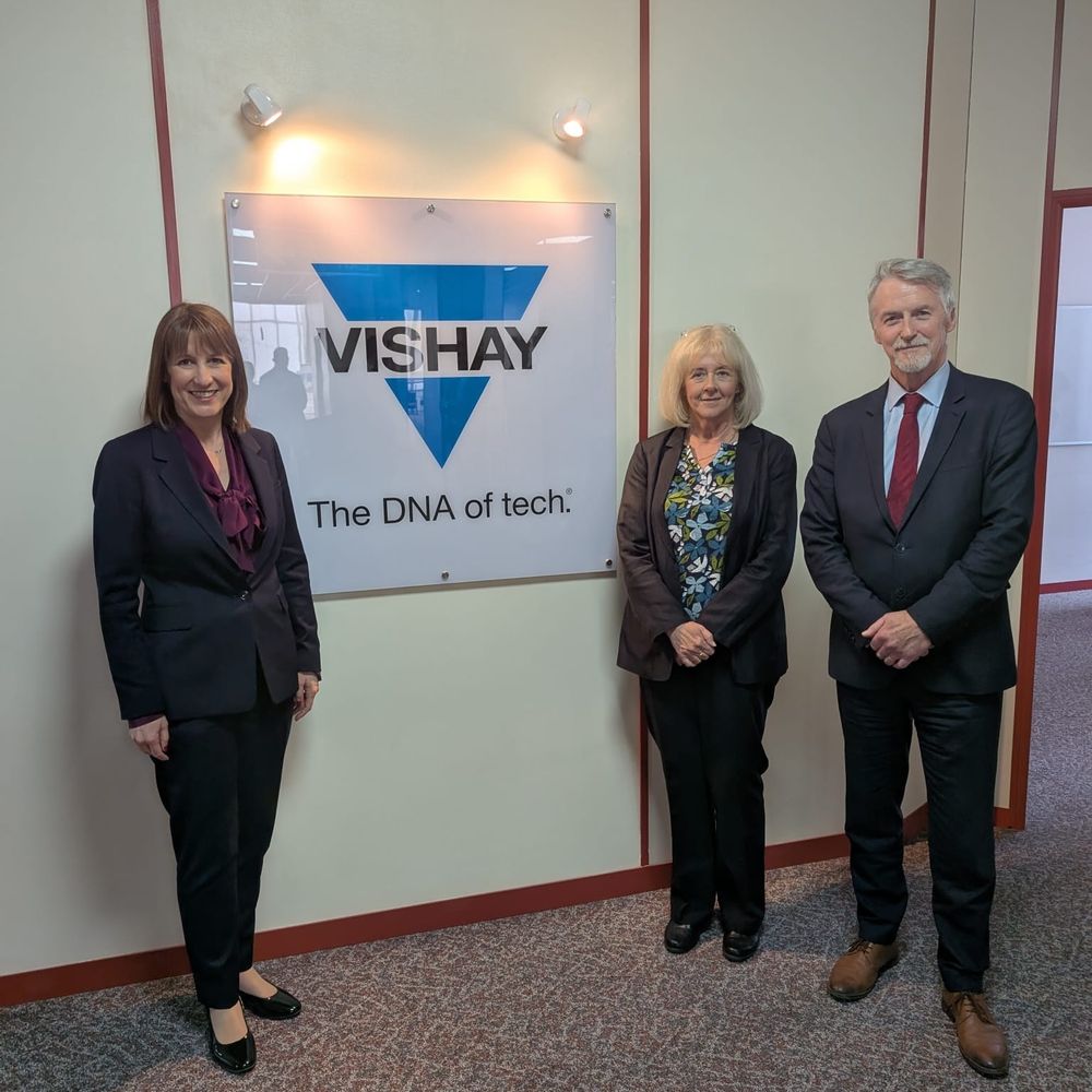 Picture of Rachel Reeves, Ruth Jones MP and Huw Irranca-Davies MS infront of the Vishay sign. The Vishay sign reads "The DNA of tech".