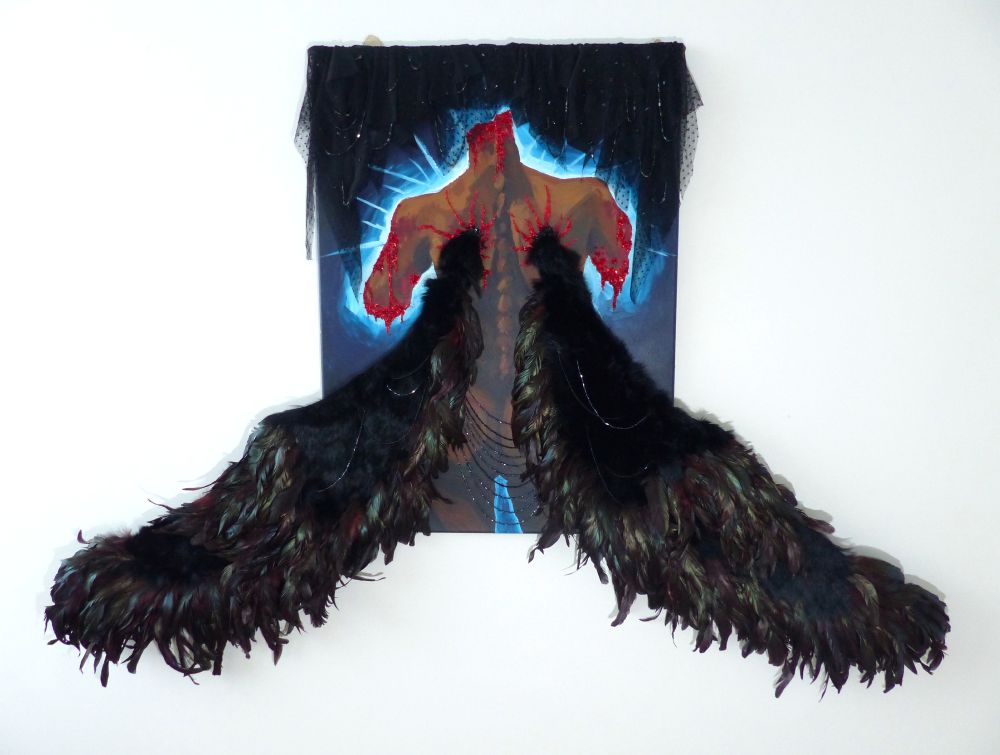 photo of a mixed media painting representing a dark skinned person, seen from the back, with head and arms missing and big wings (covered with feathers) sprouting out of the shoulder blades and jutting out of the frame. There is red beading around the wounds. black beaded fabric partially covers the top of the piece.