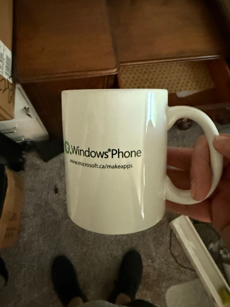 White coffee cup with "Windows Phone, www.microsoft.ca/makeapps"