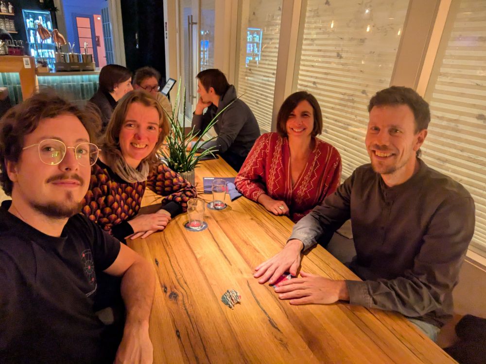 Three ZMBP junior PIs (Mau, Margot and Isa) and Sebastian sitting in a bar with some empty glasses