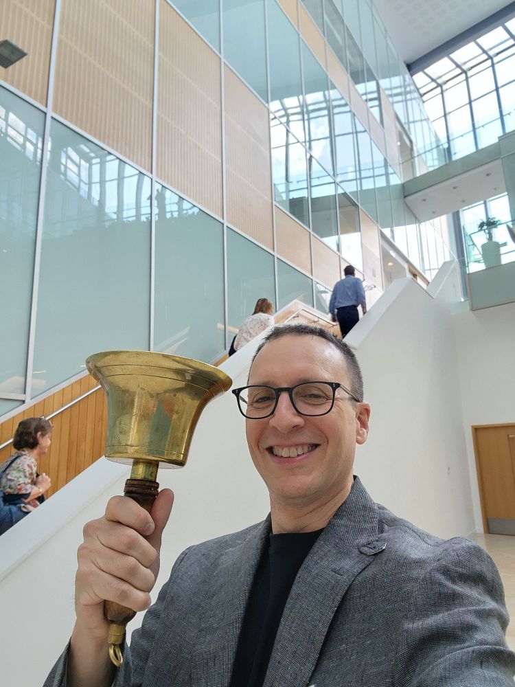 John ring's the LMB seminar bell to call the audience back in after a coffee break.