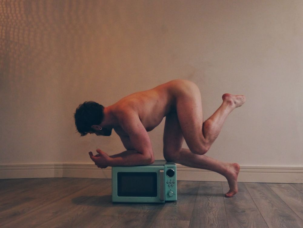 Boy bent over microwave