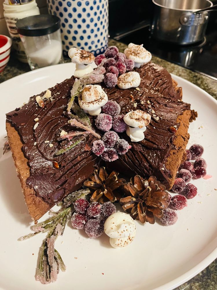 Quite possibly the most beautiful yule log ever to have been made, with candied cranberries and rosemary, and mushrooms made from meringue.
