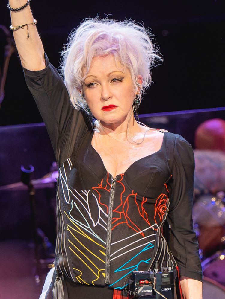 Cyndi Lauper with her fist raised at her concert
