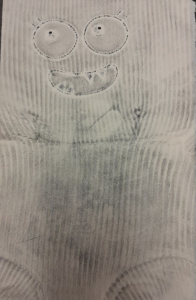 Black and white imprint of a striped monster stuffed toy