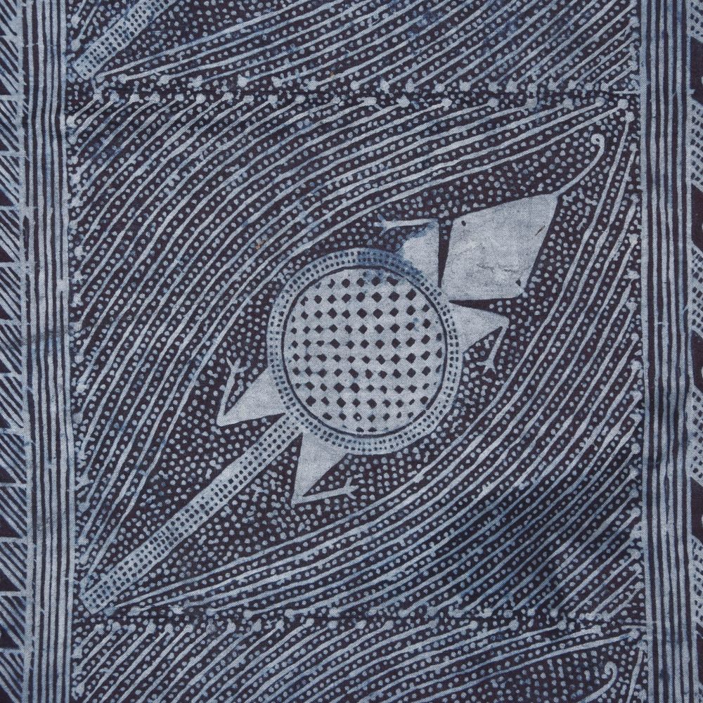 Textile with intricate design in light and dark blues, featuring a stylised depiction of a creature in between blue lines.