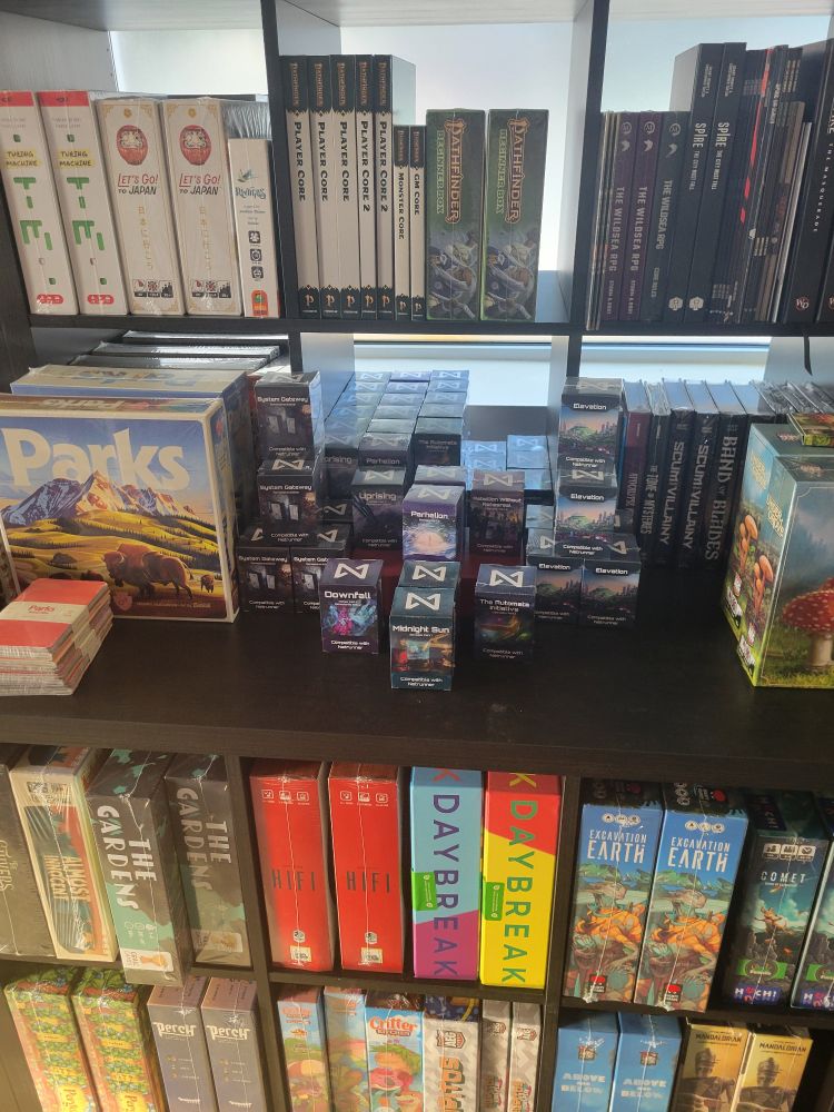 A shelf full of netrunner sets at a game store. 