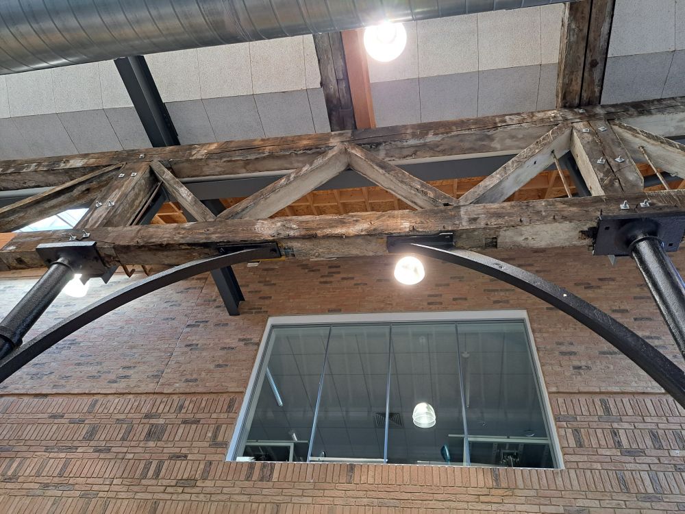 Window in wall inside the UTC with wooden beams inside.