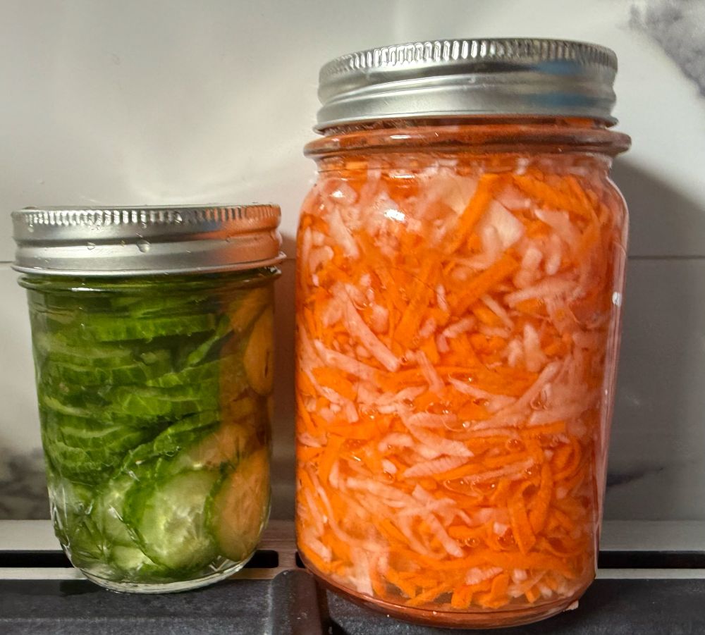 Jars of pickled carrot/daikon and pickled cucumber.