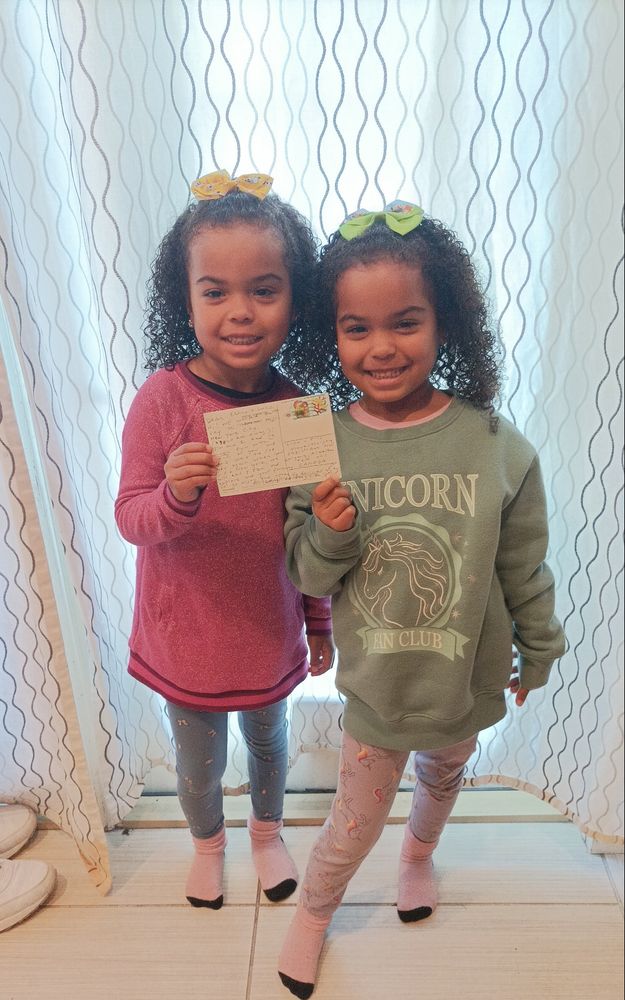 Two girls holding a postcard