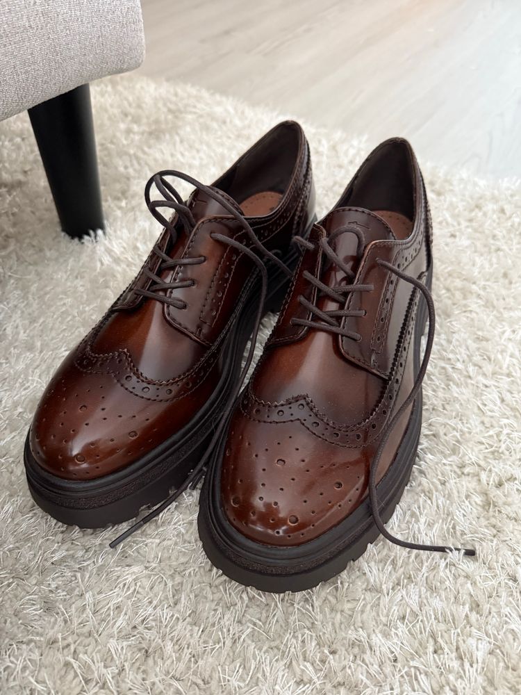 a closeup of the same shoes, there’s circle detailing on the front of the shoe