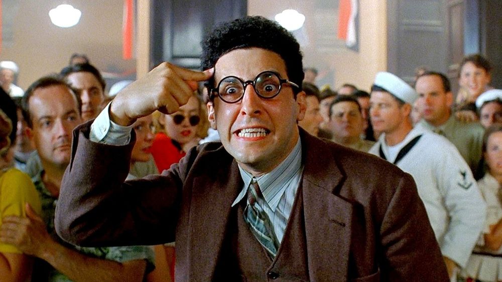 Scene from Barton Fink where the lead character is pointing at his head with his finger. 