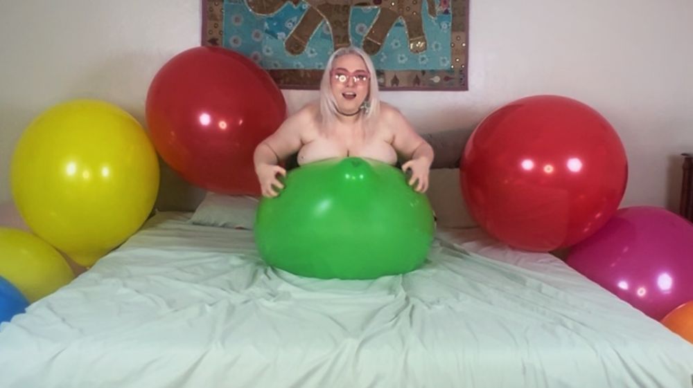 Blonde girl, nude, laying on a big balloon with her nails on the balloon. Teasing to pop it. 