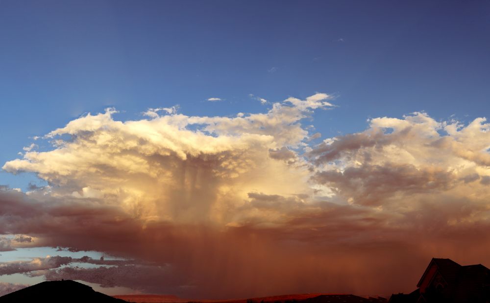 Sunset picture looking east, blue skies, white clouds, red clouds. Panorama composite