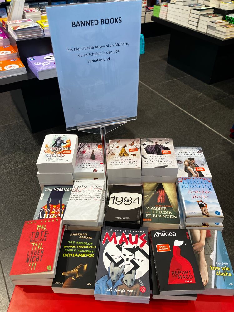 Fotograph shows a table with covers of books translated into German:
back row: 5 books by Sarah J. Maas
middle row: Toni Morrison, Bluest Eyes; Steven Chbosky, The Perks of Being a Wallflower; Orwell, 1984; Sara Gruen, Water for Elephants;
Front row: Jay Asher, 13 Reasons Why; Sherman Alexie, The Absolutely True Diary of a Part-Time Indian; Art Spielman, Complete MAUS; Margaret Atwood, The Handmaid‘s Tale; John Green, For Alaska.