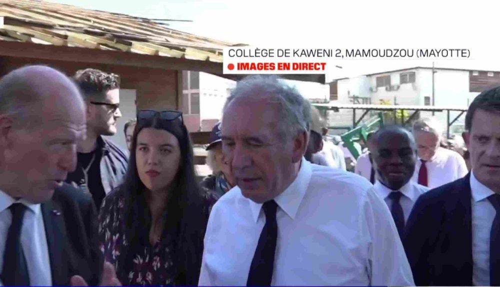 François Bayrou à Mayotte qui parle à quelqu'un, sur le côté on entrevoit Manuel Valls.