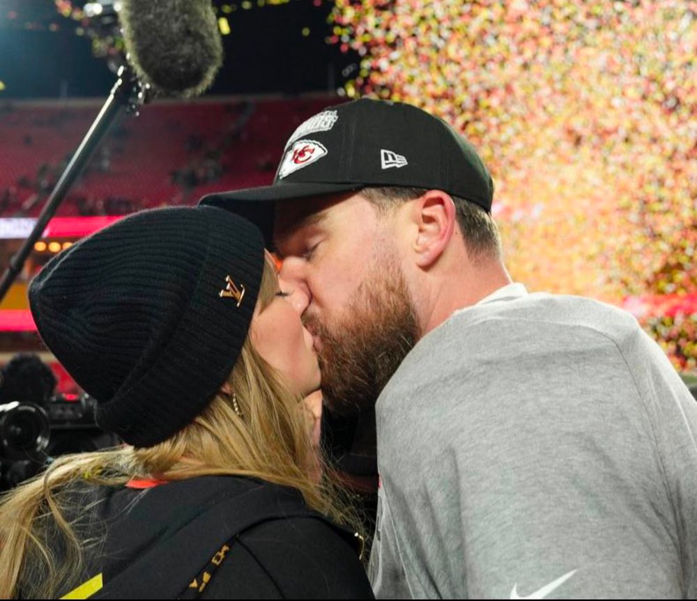 Taylor and Travis kissing after the game 