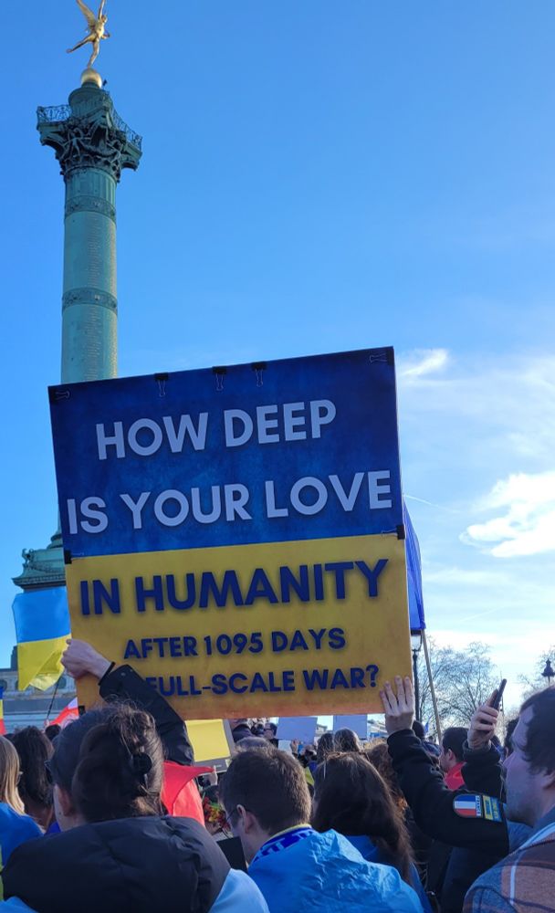 Pancarte sur fond de drapeau ukrainien. " how deep is your love in humanitu after 1095 days of scull- scale war?"
En arrière plan, la colonne de la Bastille.