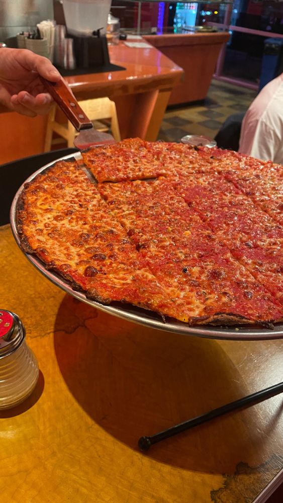 A delicious thin crust tavern-style cheese pizza cut into squares and delicately resting atop an elevated serving tray